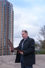 Man looking at open briefcase on the street  