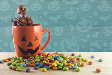 skeleton in cup with candy blue pattern wallpaper