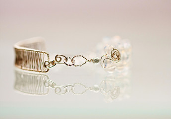 Silver jewels with colorful precious stones and light grey background