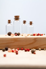 Spices and empty, small glass bottles with wooden texture