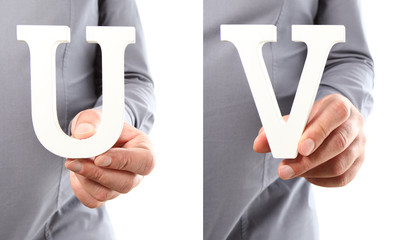 Hands holding letter U and V from alphabet isolated on a white background