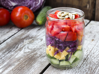 Healthy homemade mason jar salad with cucumber, cheese, tomato,