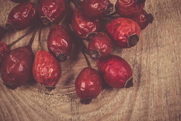 Dried rose hip berries on the wooden table.