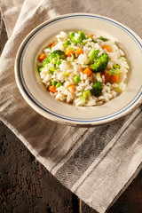 Bowl full of steamed veggies and ristotti risi bisi on napkin