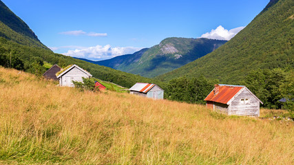Fototapeta na wymiar Typical wooden cabins in a valley in Norway