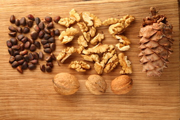Walnut and pine nuts on a cutting board made of oak/ Walnut and pine nuts on a cutting board made of oak