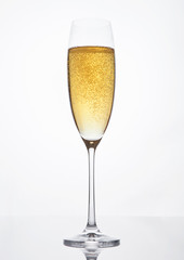 Glass of sparkling champagne with bubbles on white