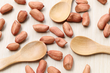 peanut and wooden spoon on wood background.