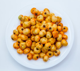 many yellow hawthorn on a white plate. in  studio