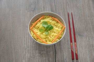 Boiled saffron rice with vegetables in a bowl, on wooden table