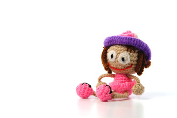 Knitted small handmade doll on white background