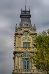 Fototapeta na wymiar Royal decoration of yellow tower on grey sky background in Barcelona, Spain