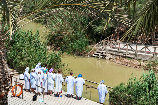 group of pilgrims going baptize at river jordan, israel