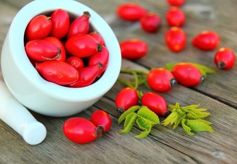 mörser und hagebutten auf holz