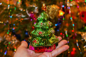 Glass vintage toy green Christmas tree on the open palm of hand