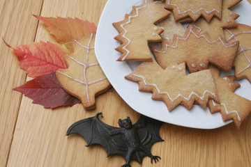 biscotti per Halloween a forma di pipistrello su piatto su tavolo di legno