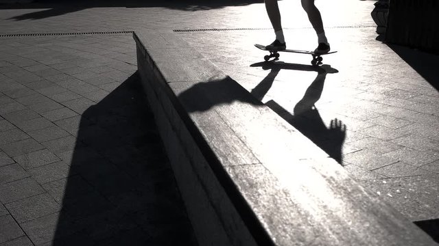 Legs on skateboard doing trick. Shadow of skateboarder. The perfect kickflip. Skills are progressing.