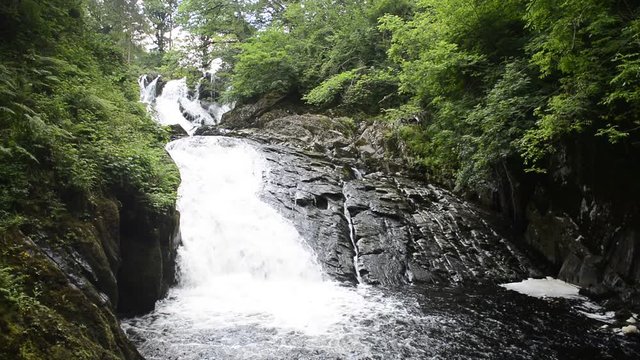 White water waterfall over rocks in summer surrounded by trees, Betws y Coed, Wales, A European landscape