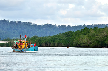 An old, rusty fishing trawler returning to harbor
