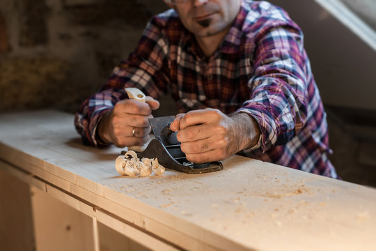 Carpenter Woks With Plane Onwooden Tabletop