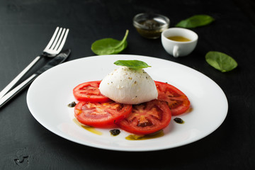 Caprese salad with mozarella cheese, tomatoes and basil