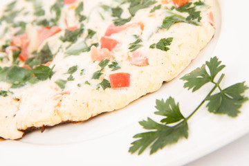 Omelette with tomatoes, fresh spinach and parsley