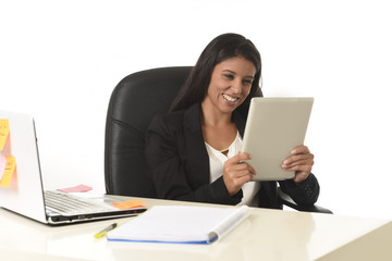 hispanic businesswoman sitting at office computer desk smiling happy using digital tablet