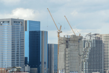 Fototapeta na wymiar Construction / View of construction site on city background. Focus on building under construction.