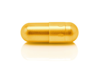 Gold pill capsule isolated on white background