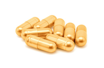 Gold pill capsule isolated on white background