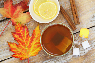 Tea, autumn leaf, lemon, star anise and cinnamon on rustic wood
