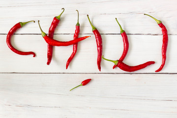 Chili word composed of red hot chili peppers, top view.