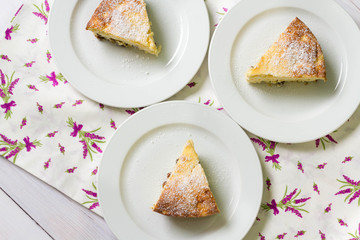 Three slice of cheese cake on kitchen table, top view.