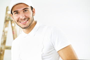 Portrait of young worker..
Young worker posing and smiling. Ladder in a background. 
