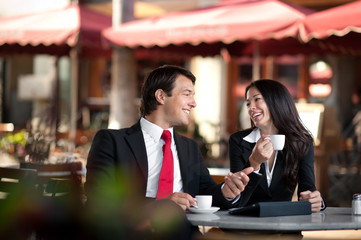 Businessman and Businesswoman Discussing Digital Tablet at Sidew
