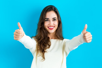 Happy young woman giving thumbs up