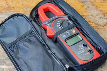 Clamp multimeter with accessories on a table in a workshop