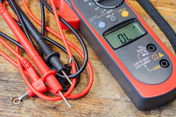Clamp multimeter with accessories on a table in a workshop