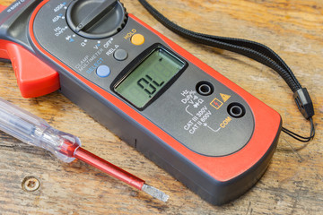 Clamp multimeter with accessories on a table in a workshop