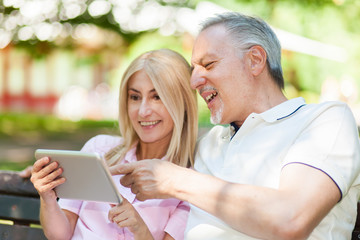 Mature couple using a digital tablet outdoors