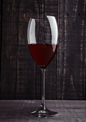 Glass of red wine with reflections on wooden board