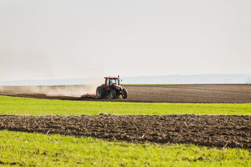Farmer in tractor preparing land with seedbed cultivator