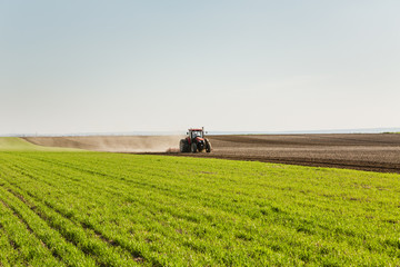 Farmer in tractor preparing land with seedbed cultivator