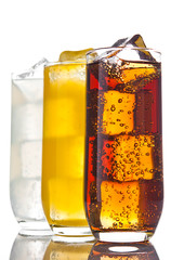 Glasses with cola orange soda and lemonade ice