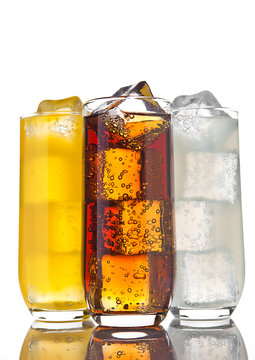 Glasses with cola orange soda and lemonade ice