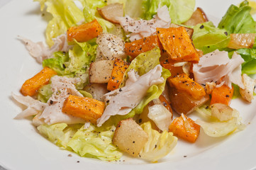 Organic turkey with roasted sweet potatoes,turnips and pears with pepper on a round white plate-paleo diet