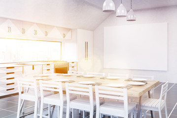 Sunlit kitchen with fridge, TV set and gray furniture