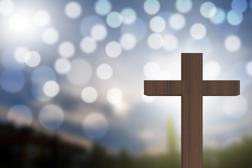 3D rendering of wooden cross on a blue sky with bokeh