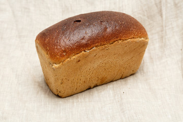 Буханка чёрного хлеба на льняной ткани