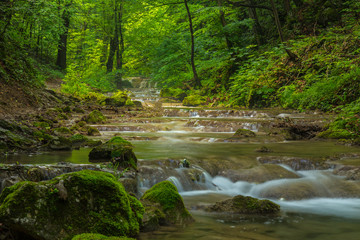 Pristine waterfalls deep in the woods, on a bright sunny day in spring